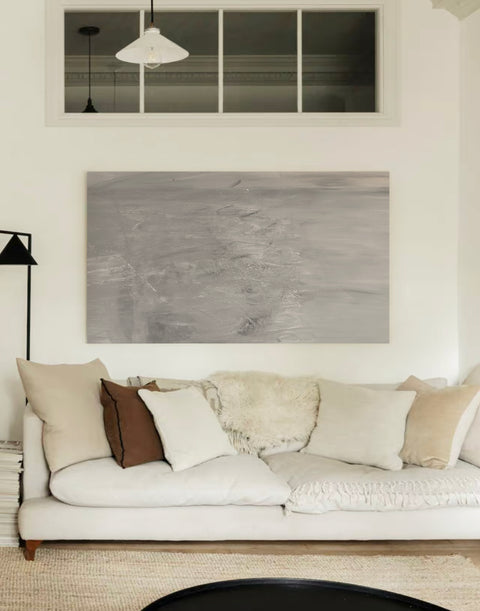 a large abstract canvas art hanging on the living room's wall