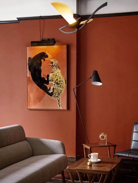 a large abstract canvas art of leopards hanging on the living room's wall