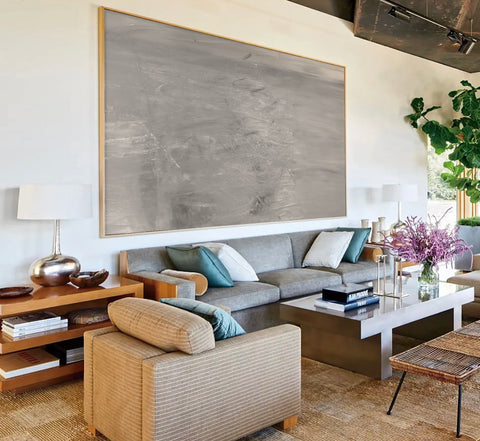 a large abstract canvas art hanging on the living room's wall